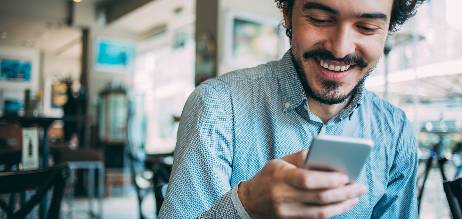 Ein Mann hält sein Handy in der Hand und schaut darauf