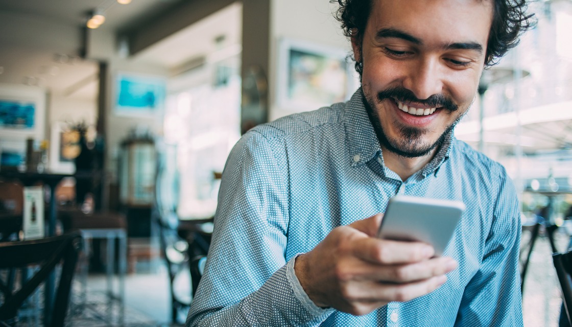 Ein Mann hält sein Handy in der Hand und schaut darauf