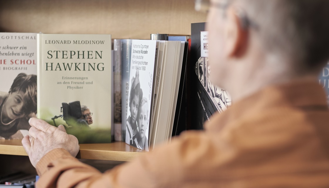 Edgar Schuster looking at the books in his bookstore