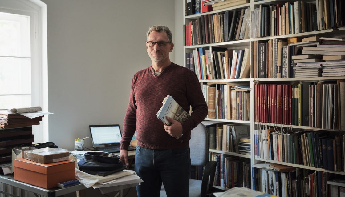 Lutz Oberländer vor seinem Bücherregal